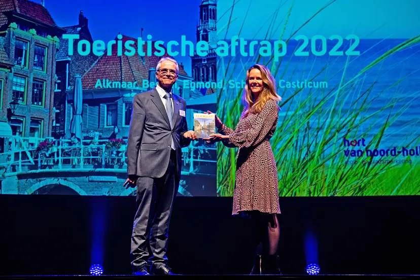 melanie goudsblom marketingmanager alkmaar marketing reikt het eerste exemplaar van het toeristisch magazine uit aan wethouder pieter dijkman