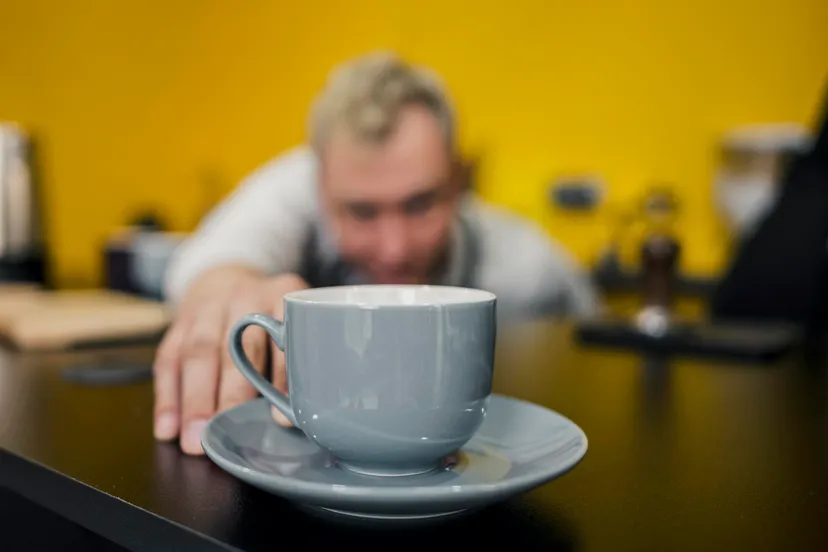 front view defocused barista looking cup coffee