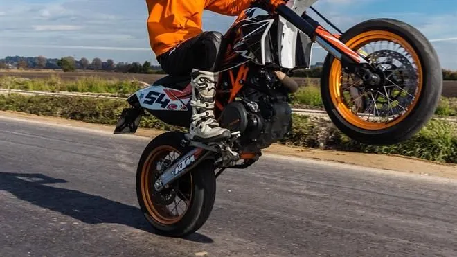 rechtbankmotor wheelie rijden op achterwiel liggende foto