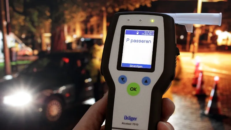 close up hand agent die alcoholcontroleapparaat vasthoudt