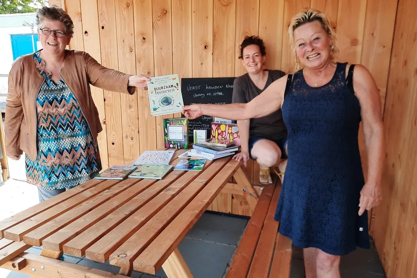 foto overhandiging tuinboeken buurttuin links bibliotheekmedewerker aafke vlaanderen oldenzeel rechts vrijwilliger annette achter tineke hopman