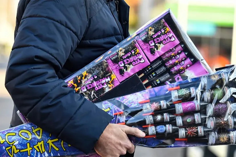 man loopt met handenvol vuurwerk