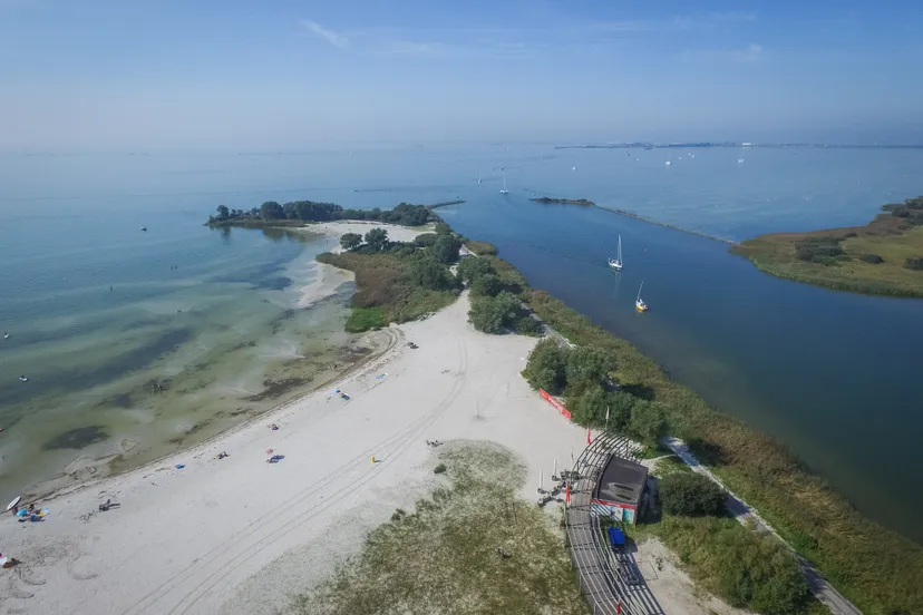 makkum strand en pier en zeilboot in vaargeul ijsselmeer drone zomer