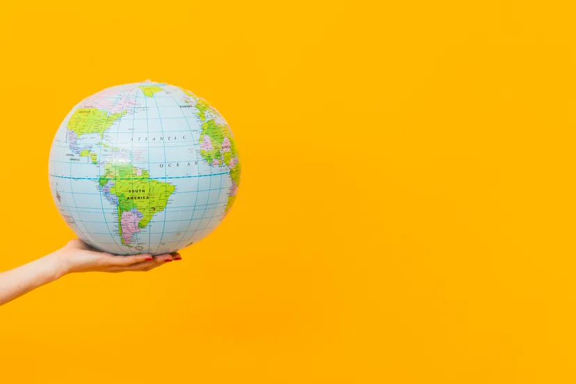 side view hand holding earth globe with copy space