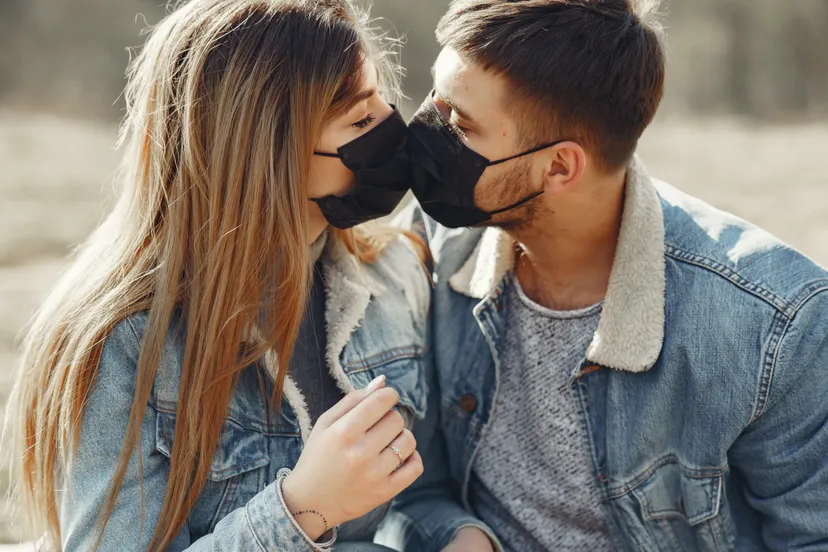 loving young couple kissing while wearing black medical 4005101 e1593083348821