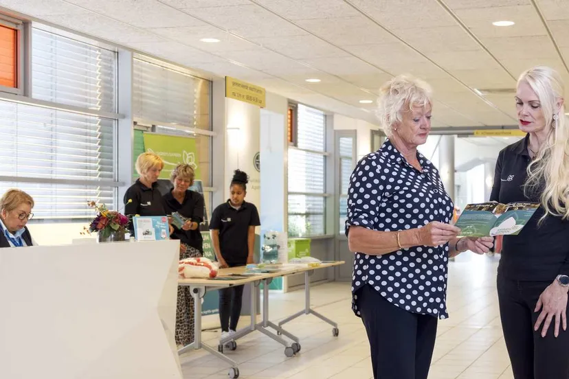 vrijwilliger-sigrids-garden-rechts-geeft-informatie-aan-een-patient