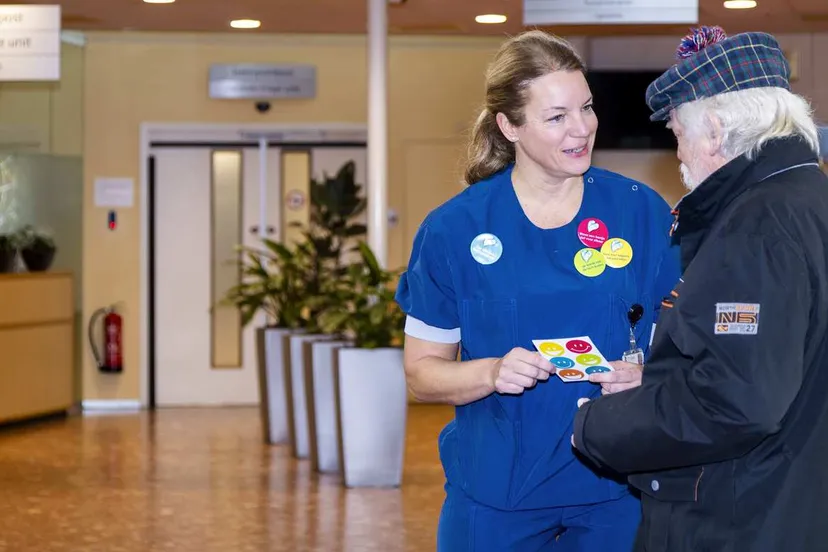 Collega Miranda Savenije deelt buttons uit aan bezoekers en patiënten