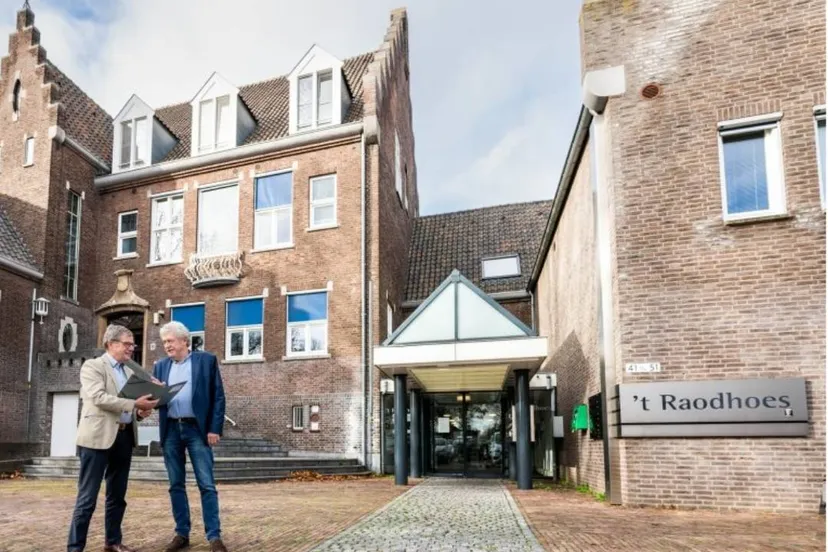 Wethouder Pustjens en wethouder Meuwissen bij het voormalige gemeentehuis in Susteren