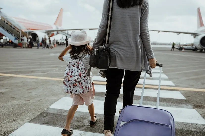 mother daughter join hands walking with suitcase23392