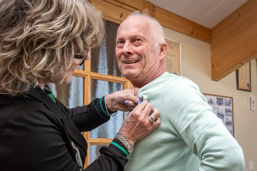 burgemeester speldt versierselen op bij dhr troost