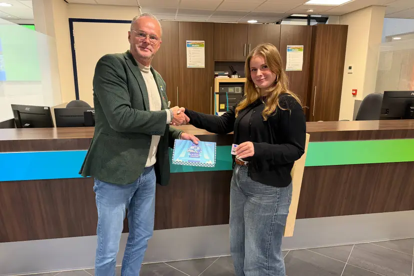 Wethouder Hans Veentjer reikt eerste rijbewijspakketje uit aan Sophie Nagtegaal