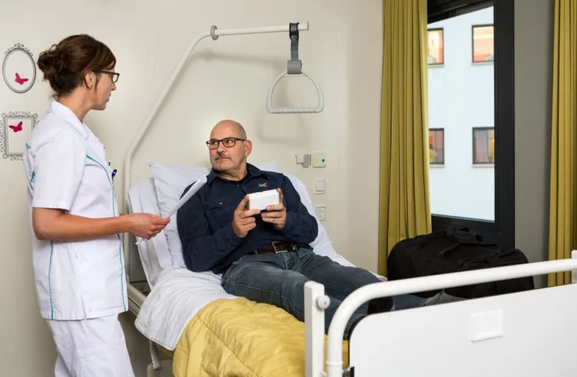 apothekersassistente geeft uitleg op verpleegafdeling