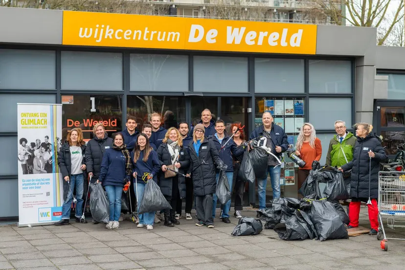 De schoonmaakploeg met het verzamelde afval bij Huis van de Wijk De Wereld