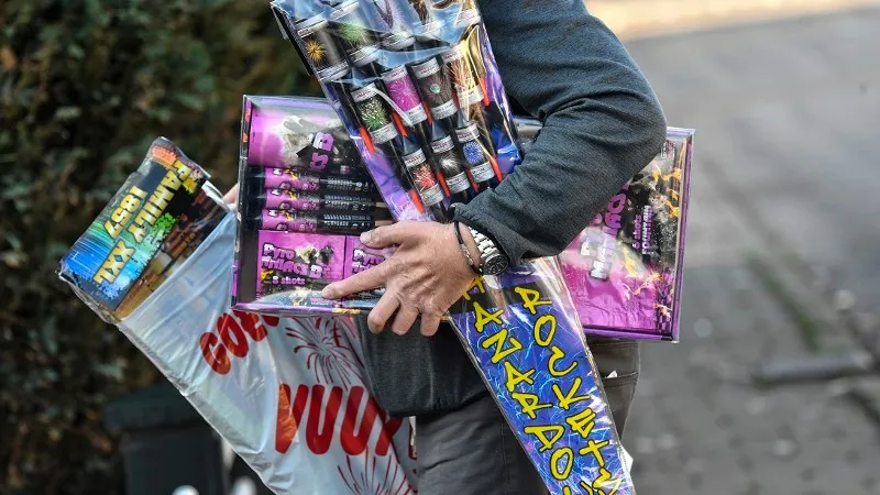 man heeft handenvol aan vuurwerk