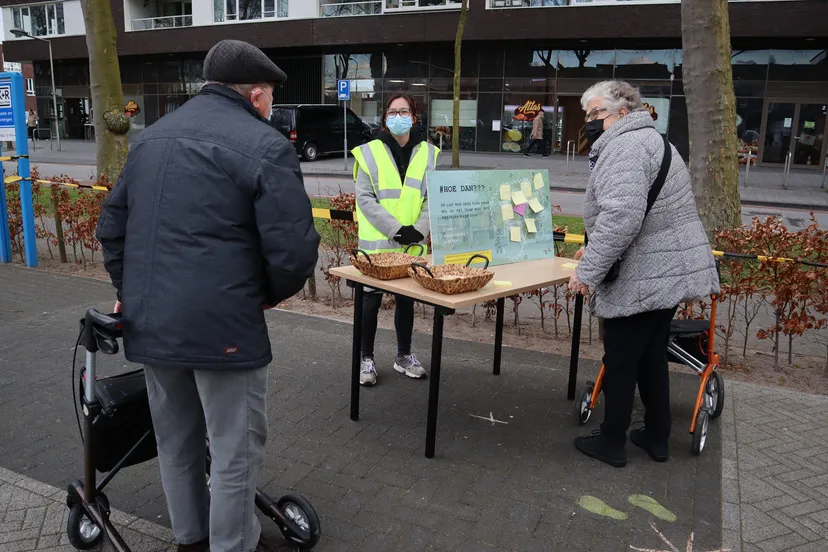 inwoners van stadsdennen bekijken een informatiebord tijdens het ommetje kiekmure