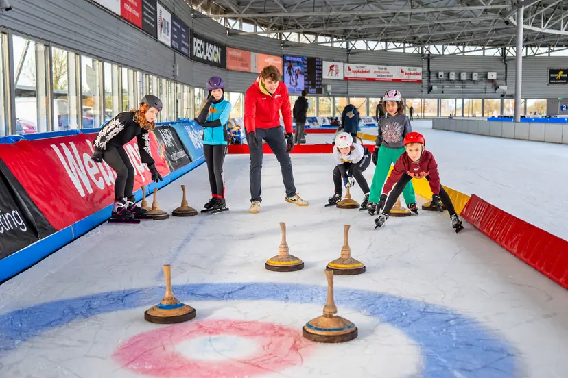 Kinderen maken plezier tijdens curling op het Alkmaars IJsplein
