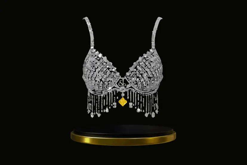 Diamond-encrusted bra with  silver detailing and a gold pendant, displayed above a black and gold pedestal.