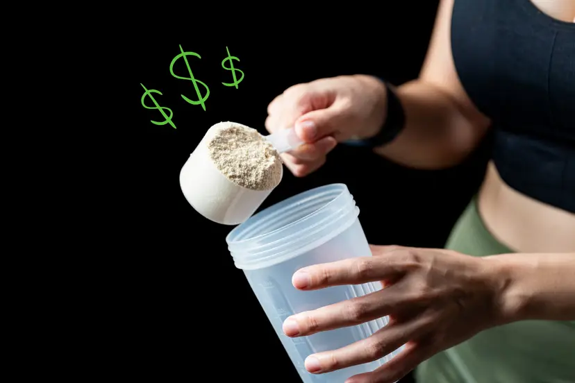 A person scooping protein powder into a shaker bottle with green dollar signs floating above the scoop.