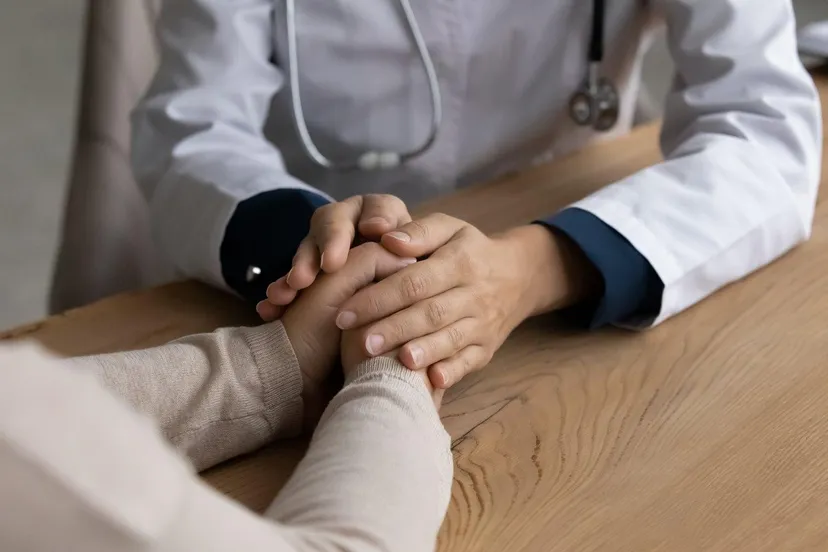 huisarts houdt hand van patient vast