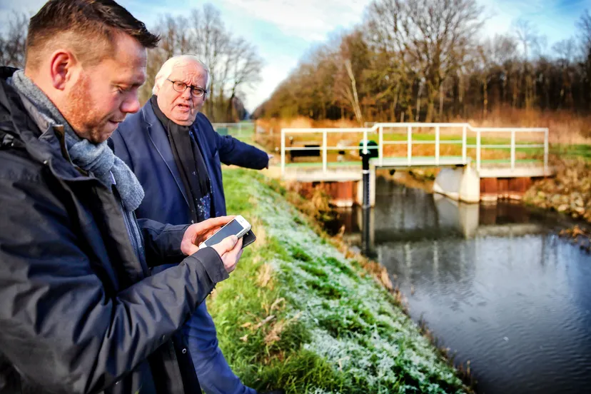 waterschapsvoorzitter ger driessen en melkveehouder jakob pustjens bekijken het peil in rosveldlossing