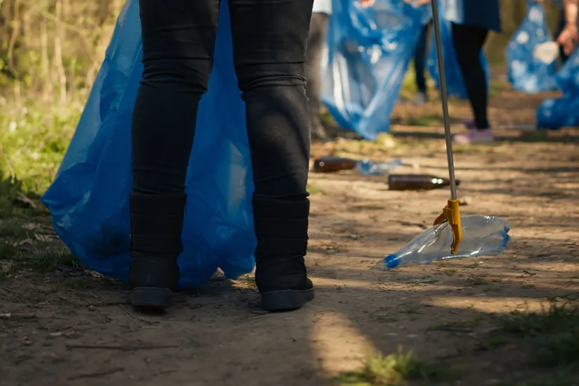 diverse activists group using claw tools grab trash plastic