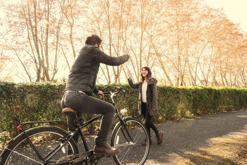 man-bicycle-greeting-woman-park