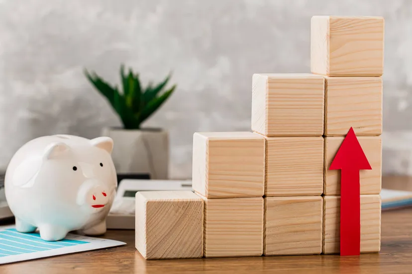 piggy-bank-with-wooden-growth-blocks-arrow-pointing-up
