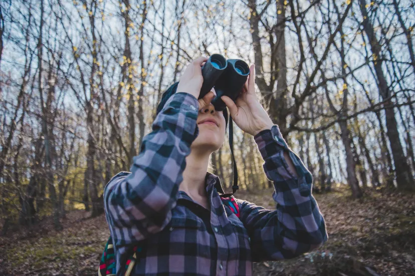 young-woman-using-binoculars-forest