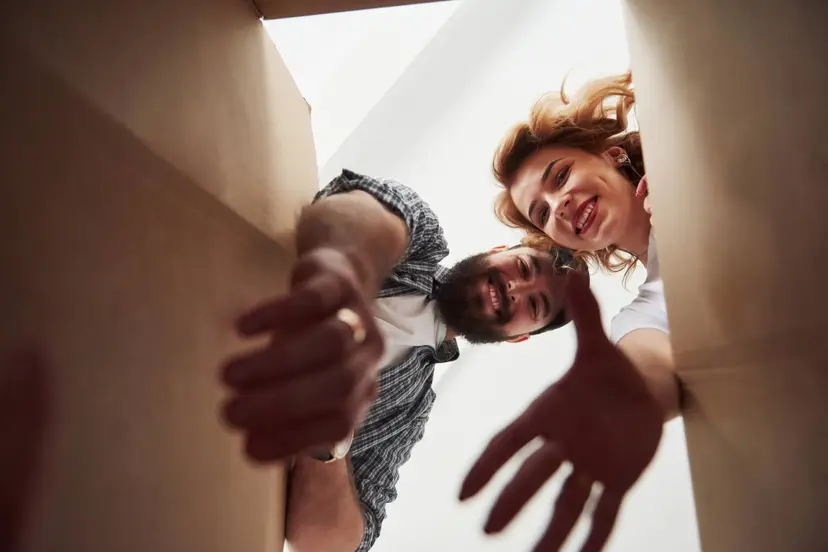 taking-clothes-from-box-happy-couple-together-their-new-house-conception-moving
