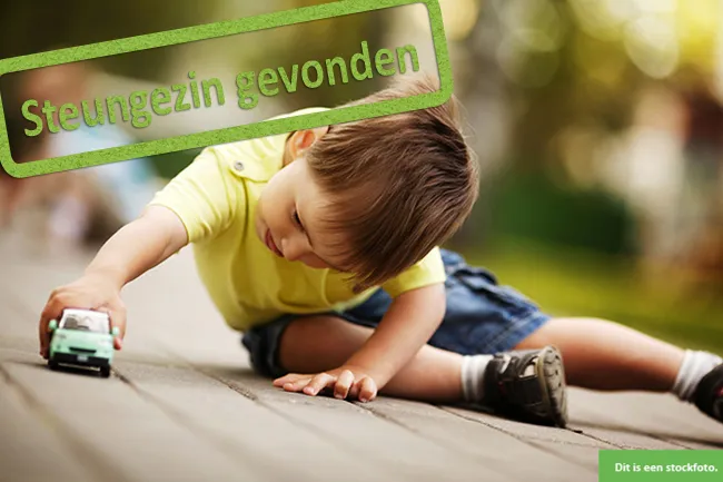 buurtgezinnensteunoudersjongen met autootje stockfoto