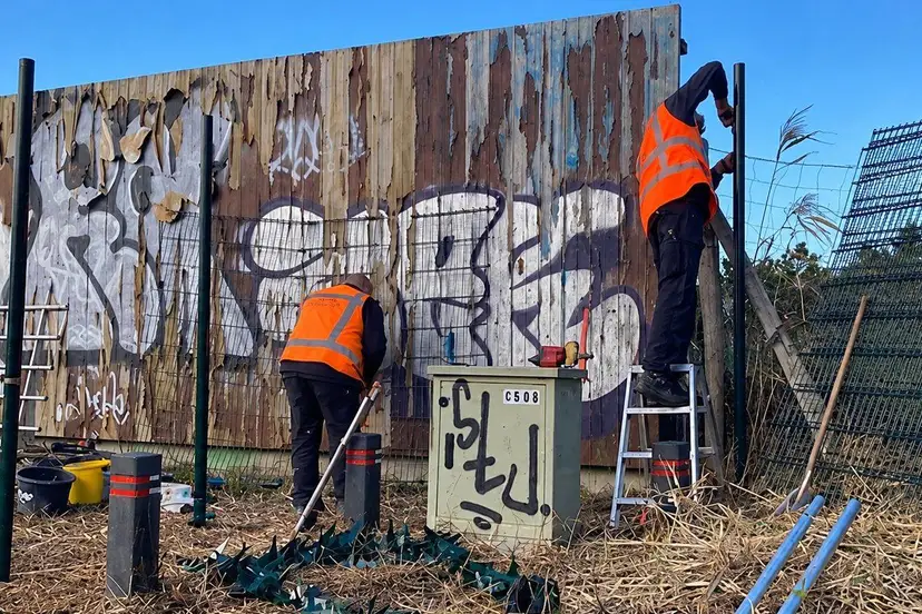 Werken aan een beschilderd hekwerk