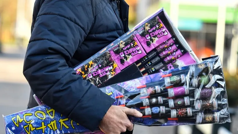 man loopt met handenvol vuurwerk