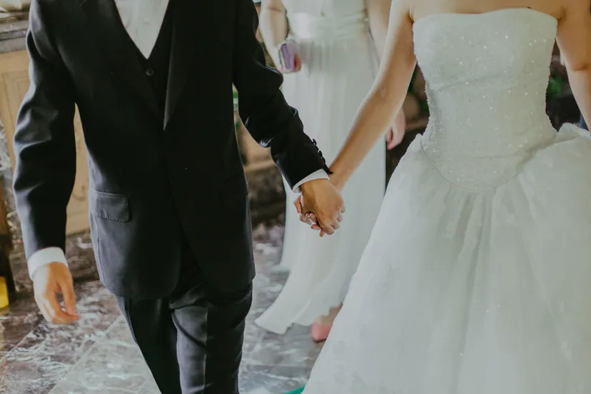 woman wearing white wedding gown holding hands with man 1043902