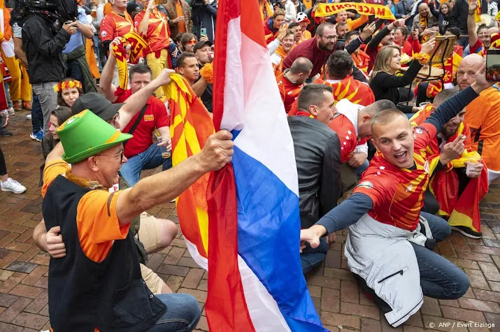 amper oranjekoorts onder winkelend publiek