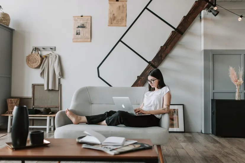 content young woman using laptop in modern living room pexels