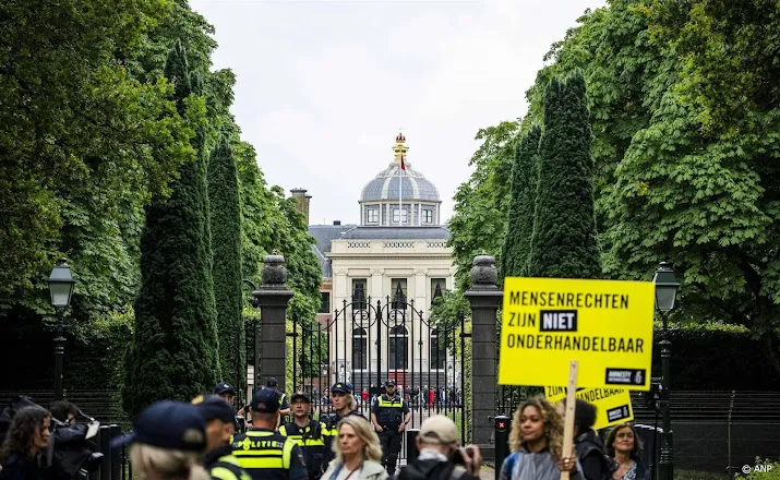 demonstranten kijken toe bij bordesscene nieuw kabinet met koning