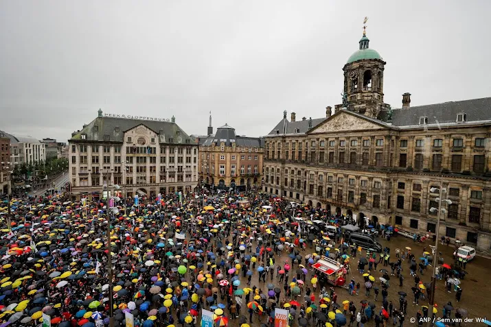demonstranten verzamelen zich op de dam voor coronaprotest