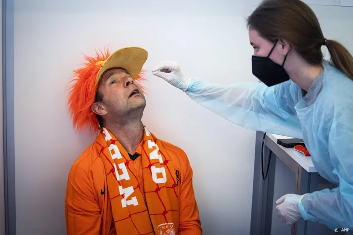 fans oranje in lange wachtrijen voor coronatest