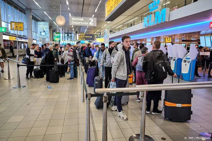 grote drukte op schiphol lange rijen reizigers bij vertrekhal