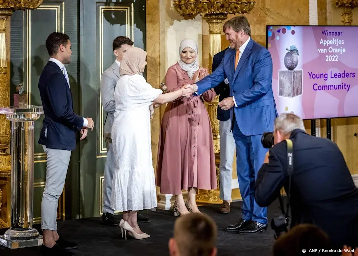 koning willem alexander reikt appeltjes van oranje uit