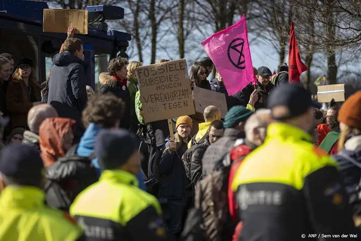 politie arresteert demonstrant die sticker op waterkanon plakt
