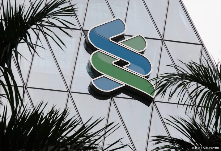 standard chartered gaat snijden in de kosten