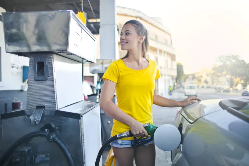 woman in yellow shirt while filling up her car with gasoline pexels