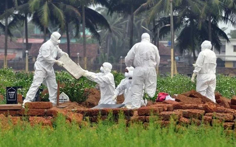 0 Doctors and relatives wearing protective gear dig a grave to bury the body of a victim who lost his 1