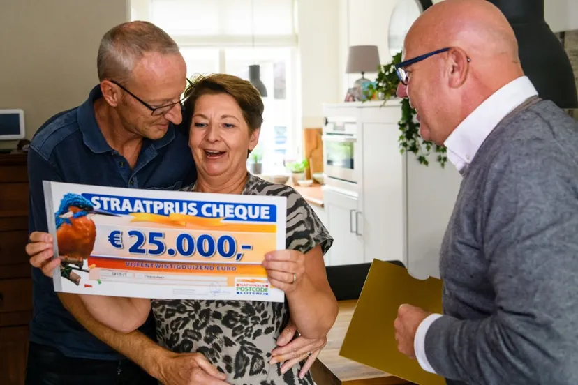 2018 09 13 sylvia en haar man uit hoevelaken worden verrast door postcode loterij ambassadeur gaston starreveld met de postcodestraatprijs cheque