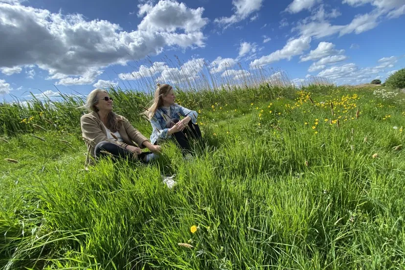 twee20vrouwen20zitten20in20het20gras20 20istock 2215005313