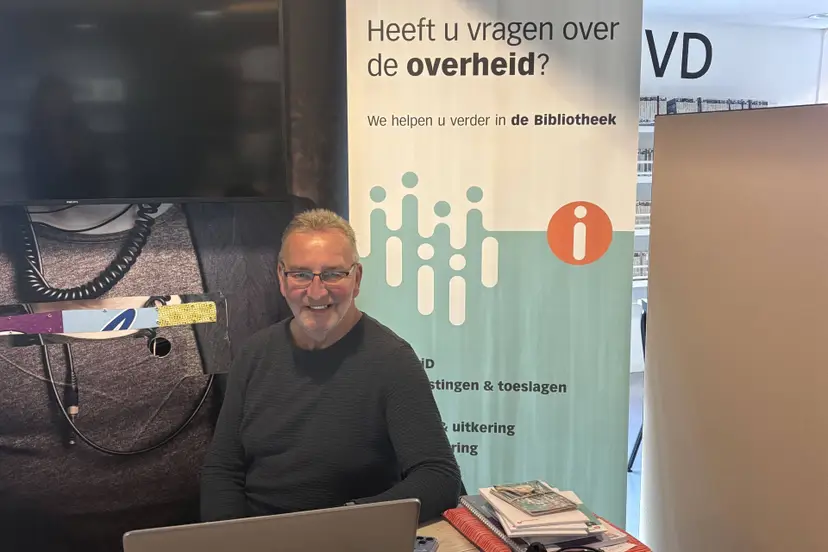 Vrijwilliger Knud zit elke donderdagochtend klaar bij het IDO in Bibliotheek Marienburg. Foto OBGZ