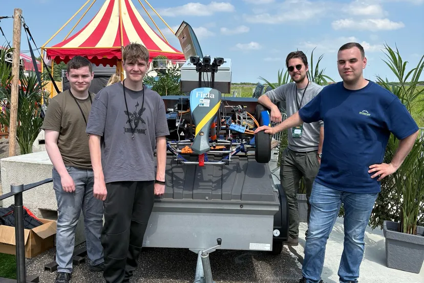 Studenten en docent Sietse Hoekstra bij hun zelfrijdende auto