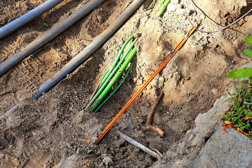 Kabels en leidingen liggen vrij in uitgegraven grond bij werkzaamheden in Nunspeet