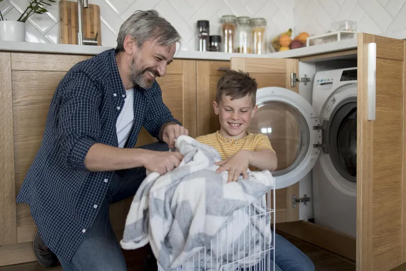 medium shot father kid doing laundry